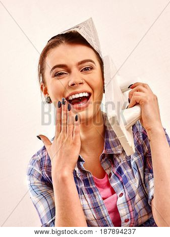 Repair home woman holding paint roller for wallpaper. Female in newspaper cap renovation apartment. Paint bank and roll paper background on isolated. Fashionable girl builder.