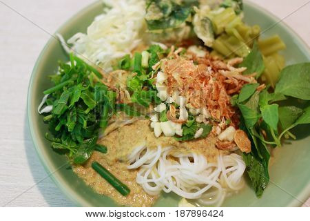 Thai Noodles (Kanom jeen) in a green dish on a food table.