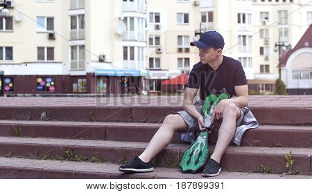 Young man with a skateboard on the street of a big city
