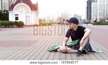 Young man with a skateboard on the street of a big city