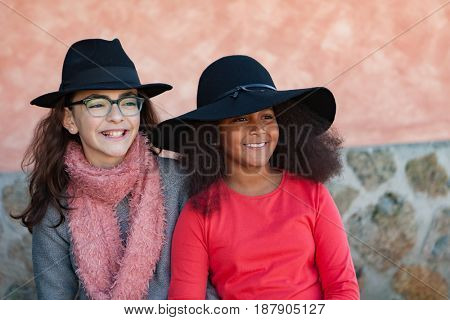 Two happy girls friends with stylish hats lauging 