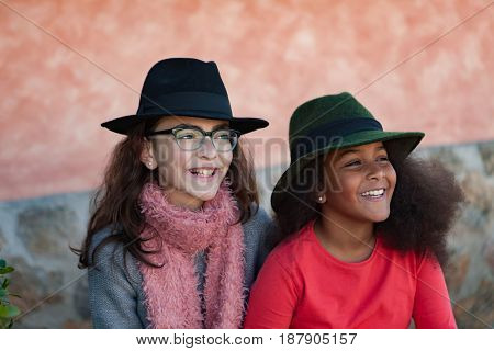 Two happy girls friends with stylish hats lauging 