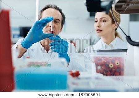 Look here. Very attentive probationer keeping mouth opened while looking at the test-tube and standing near professor