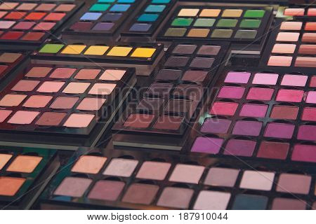 Shadows for make-up of a variety of colors on the stand.