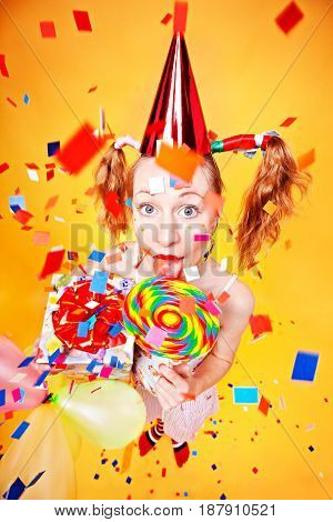 Girl with lollipop and gift confetti flying around all colorful juicy.