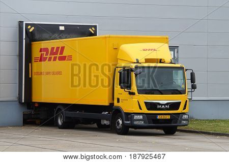 Almere, The Netherlands - May 24, 2017: DHL delivery truck at a loading dock. Nobody in de vehicle.