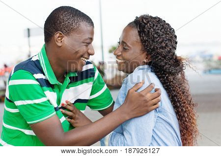 Young couple laughing together looking at each other in the eyes.