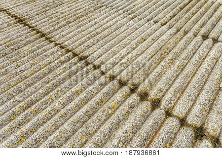 Asbestos cement sheets. Texture of old laid roofing sheets. Grey old roof.