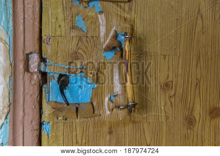 Fragment of an old door and platband where the old accessories on closing of a door, and also the handle in the form of a simple scrap of a branch are established.