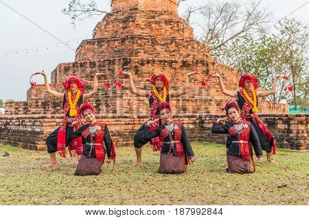 KALASIN THAILAND - FEBRUARY 20 2016: Girl and boy dancers with local dress doing Thai Northeastern traditional dance at Yaku Pagoda to celebrate Buddism event in Kalasin
