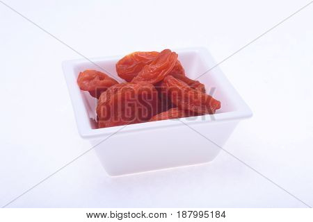 Delicious dried organic apricots on bowl isolated over white background