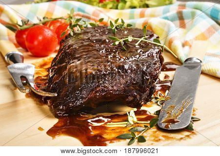 marinated pork ribs knife and meat fork on wooden board