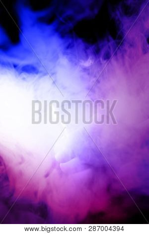 Male Hand Holds Vape In Thick Vape Fog Or Smoke. Vape Clouds Around Hand With Vape On Black Backgrou