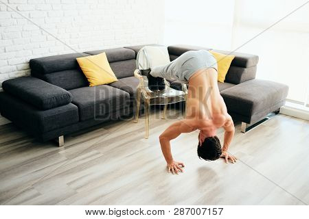 Adult Man Training Chest Muscles At Home Doing Inclined Push-ups