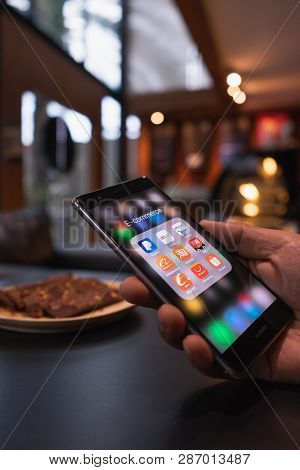 Chiang Mai, Thailand - May 09,2018: Man Holding Huawei With Icons Of E-commerce And Online Shopping 