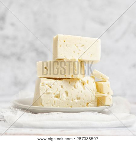 Sliced Feta Cheese On Light Background. High Key. With Copy Space.