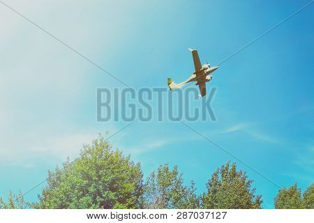 A Small Private White Plane With Screws Flies On The Background  Blue Sky With Clouds