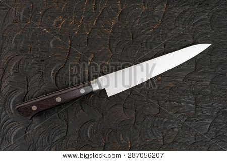 Utility knife on cutting board shot from above