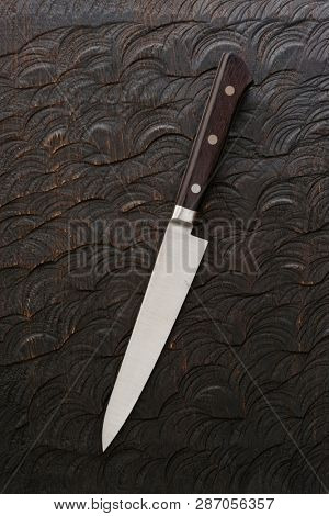 Kitchen knife on etched wooden board