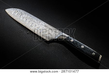 Knife With Drops Of Water Isolated On A Black Background