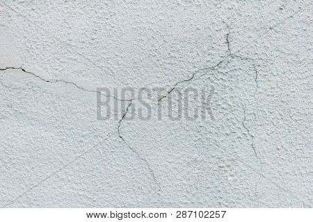 A Plaster With Cracks, A Cracked Wall, A White Wall With A Crack, A Huge Wall. Texture White Rough.