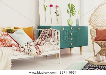 Green Cabinet With Crown Shape Handle In The Middle Of Bright Bedroom With Colorful Bedding On The B