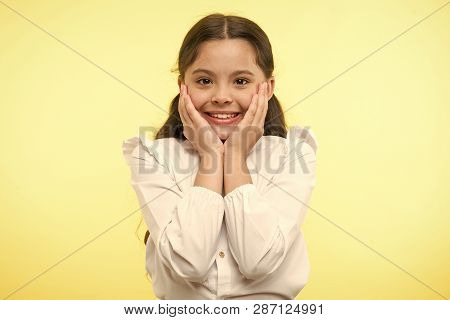 Full Of Excitement. Girl Happy Smiling Face Touches Her Cheeks Yellow Background. Schoolgirl Can Not