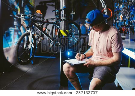 Young Handsome Stylish Man In A Cap Snapback And With A Tattoo Small Business Owner Selling A Bicycl