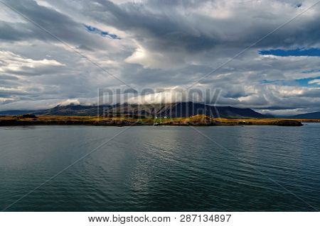 Sea Water At Mountain Coast Under Cloudy Sky In Rejkjavik, Iceland. Sea On Mountain Landscape. Beaut