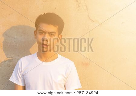 Photo Of A Young Thai Boy Is Standing Front Of The Dirty Wall In The White Shirt With Smilingly Happ