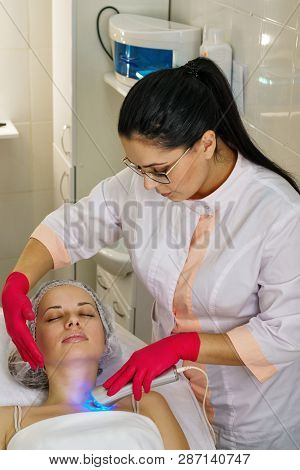 Girl In Spa Salon. Cosmetic Procedure For Rejuvenation. Ultrasonic Cleaning And Face Lift. Cosmetolo