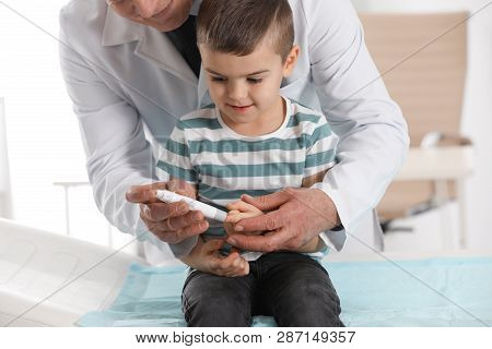 Little Patient And Doctor With Lancet Pen In Hospital, Closeup. Diabetes Control