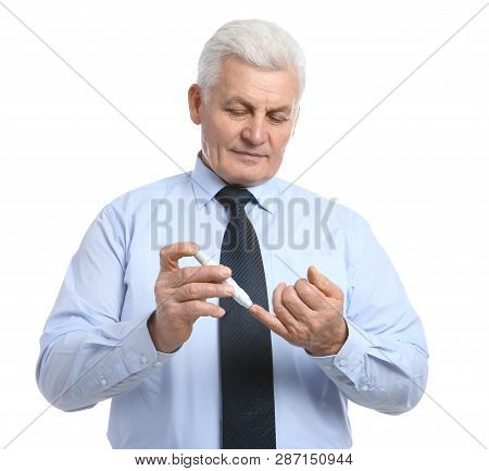 Senior Man Using Lancet Pen On White Background. Diabetes Control