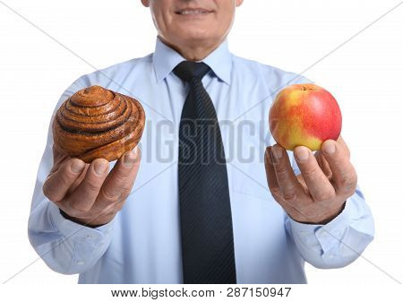 Senior Man With Pastry And Apple On White Background, Closeup. Diabetes Diet