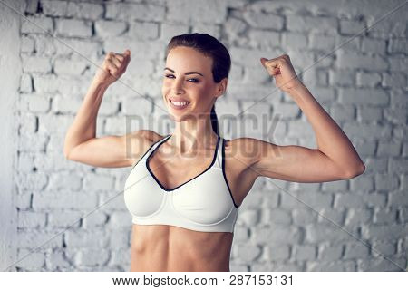Fit Young Woman Showing Bicepses Smiley Portrait