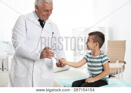 Little Patient And Doctor With Lancet Pen In Hospital. Diabetes Control