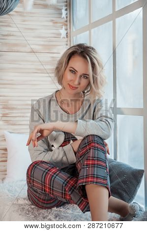 Beautiful Girl Sitting Near A Large Window.