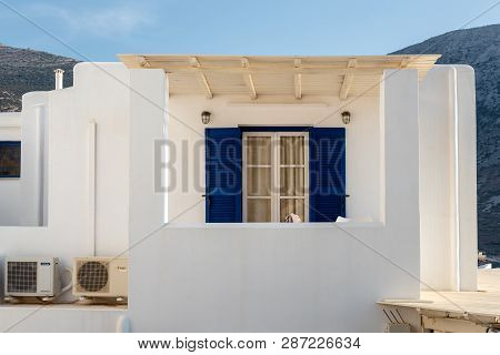 Sifnos, Greece - September 10, 2018: Facade Of A Traditional Greek House With Blue Shutters.island O