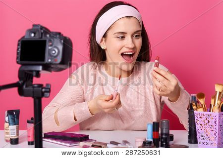 Beauty Blogger With Camera Shooots New Video For Her Vlog. Brunette Female Advertises Cosmetics Prod