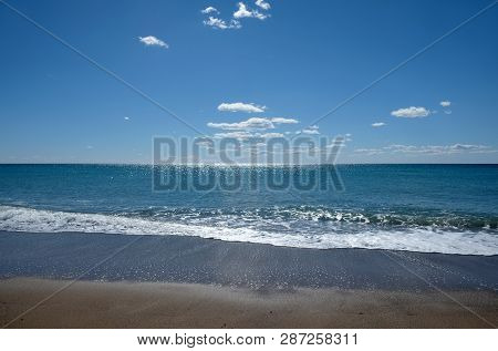 Beautiful Sieside Landscape With Calm Sea Surf With Waves Runs To The Empty Sandy Beach And And Sun 