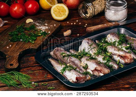 Hake Carcasses On Baking Sheet With Vegetables And Spices