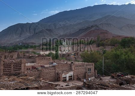 View Of The Uyghur Village Of Tuyog, With A Mosque And Mountains On The Background, Xinjiang Region,