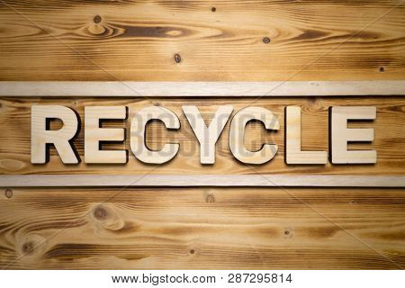 RECYCLE word made with building blocks on wooden board