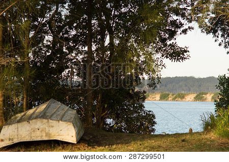 Upside Down Rowboat On The Shore Of A Peaceful River In Mossy Point Nsw
