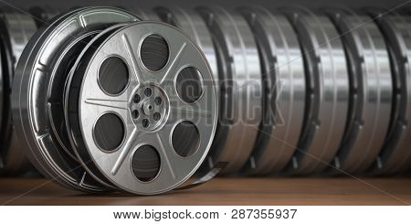 Video, cinema, movie, multimedia concept. A row of vintage film reel or  film spools with filmstrip  3d illustration