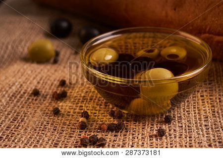 Fresh Bread Baguette With Olive Oil, Olives. Cheese And Rosemary On Wooden Background. Teasty Breakf