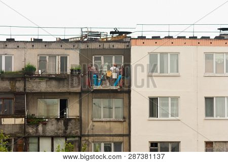 Two Workers Are Plastering The Facade Of A Building Without Observing Safety Techniques In A Cradle 