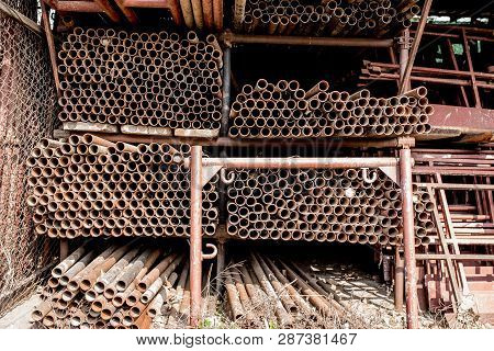 Scaffolding Storage Area In Outdoor, Detail Of Stacks Of Pipes, Poles, Used And Rusty Staffolding