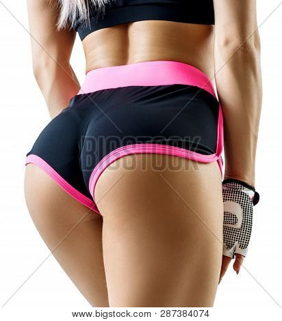 Athletic Woman In Sportswear Demonstrated Her Perfect Muscular Buttocks. Isolated On White.