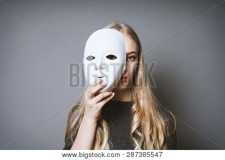 Teen Girl Hiding Her Face Behind Mask - Identity Or Personality Concept